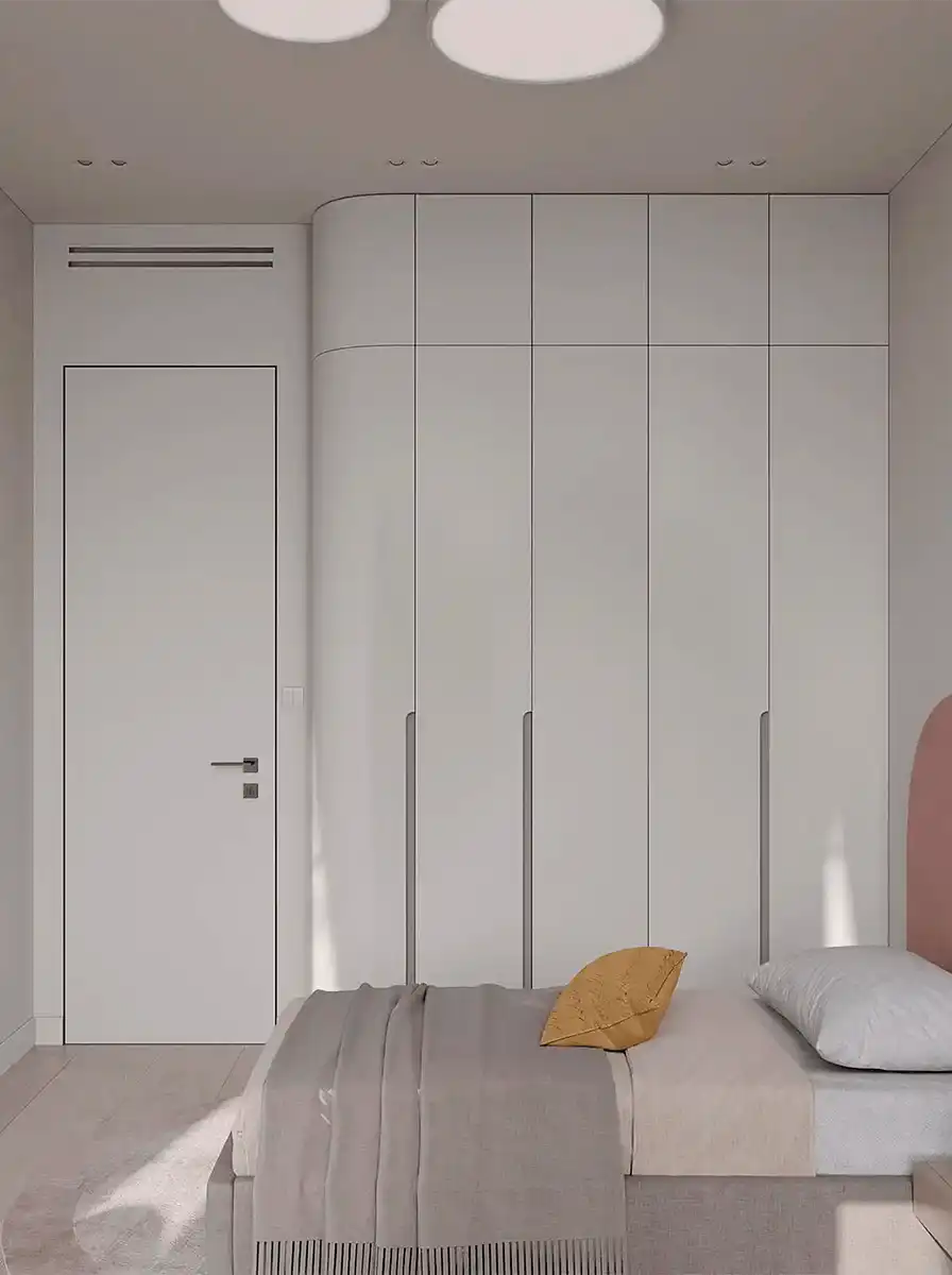 Светлая спальня со встроенным шкафом до потолка, скругленным угловым модулем, мягкой кроватью и лаконичной светлой отделкой.