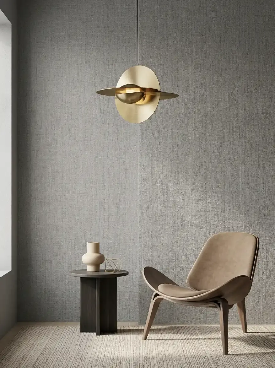 Современный интерьер с флизелиновыми обоями светло-серого оттенка, креслом и подвесным светильником.