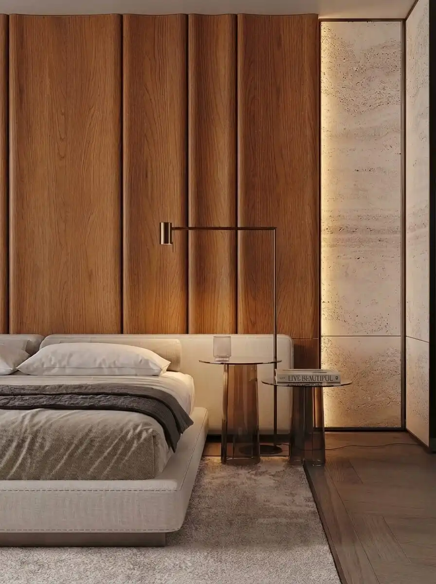 Современная спальня с мягкой кроватью, деревянной акцентной стеной, каменной отделкой, теплой подсветкой и лаконичными столиками