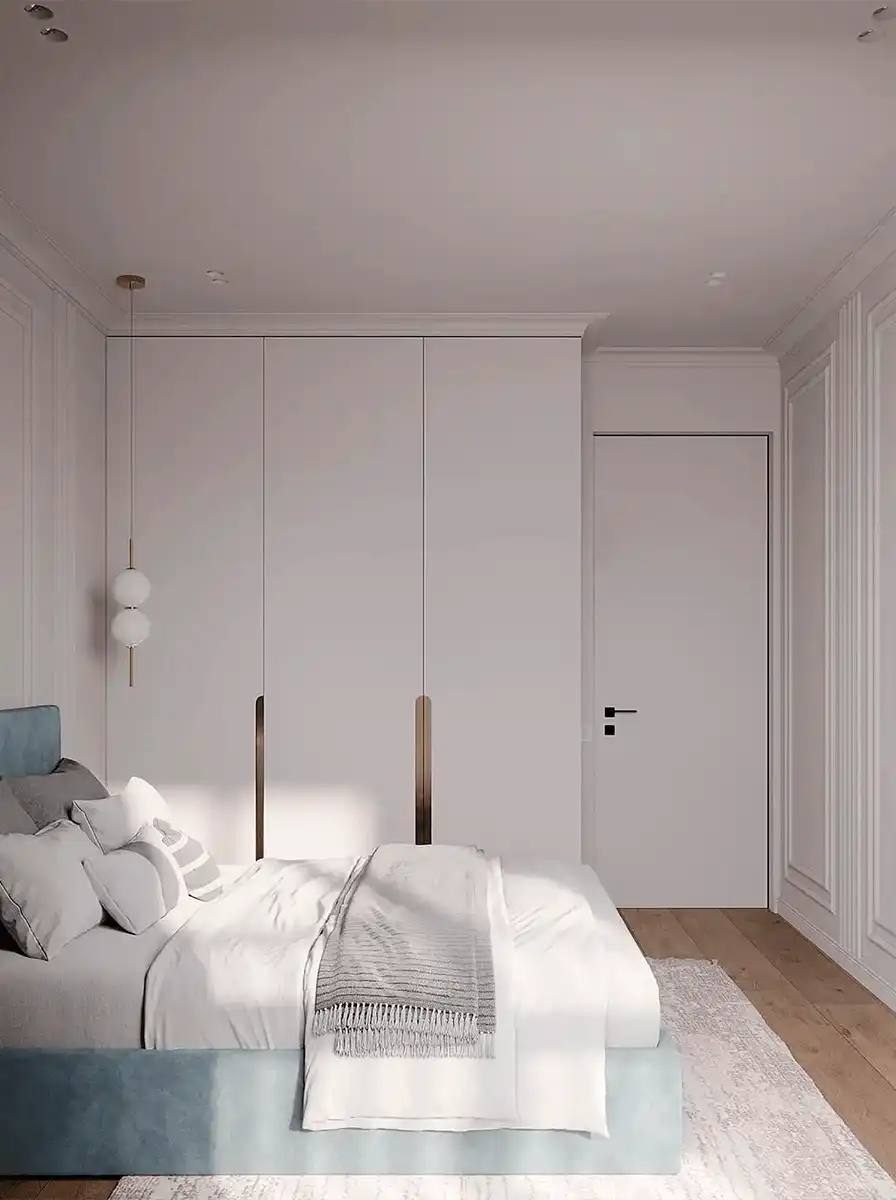 Светлая спальня с голубой мягкой кроватью, встроенным белым шкафом, молдингами на стенах и светлым текстилем.